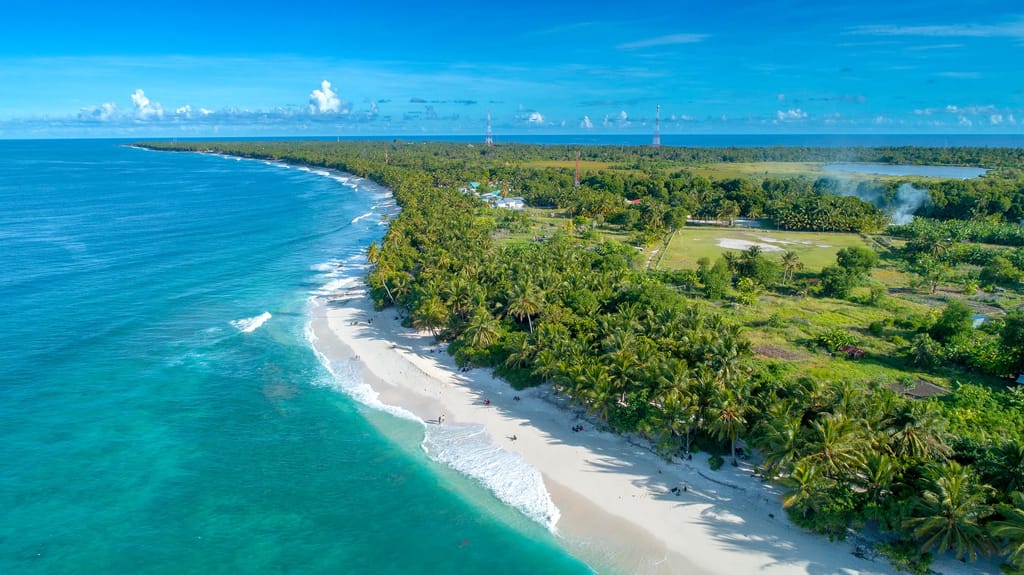 Aerial view of Thoondu beach with turquoise water, white sand and the town’s edge